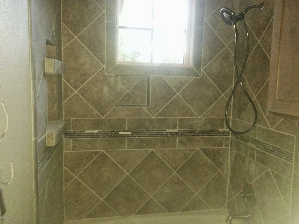 Custom diagonal tile shower with window and mosaic accent band